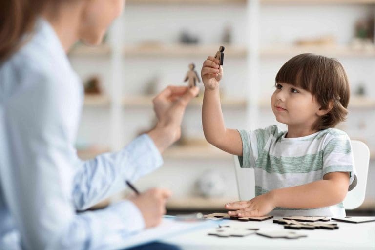 Katie Parker engaging in play therapy with child.