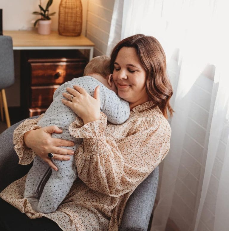 Katie Parker nursing a baby during a perinatal counselling session.